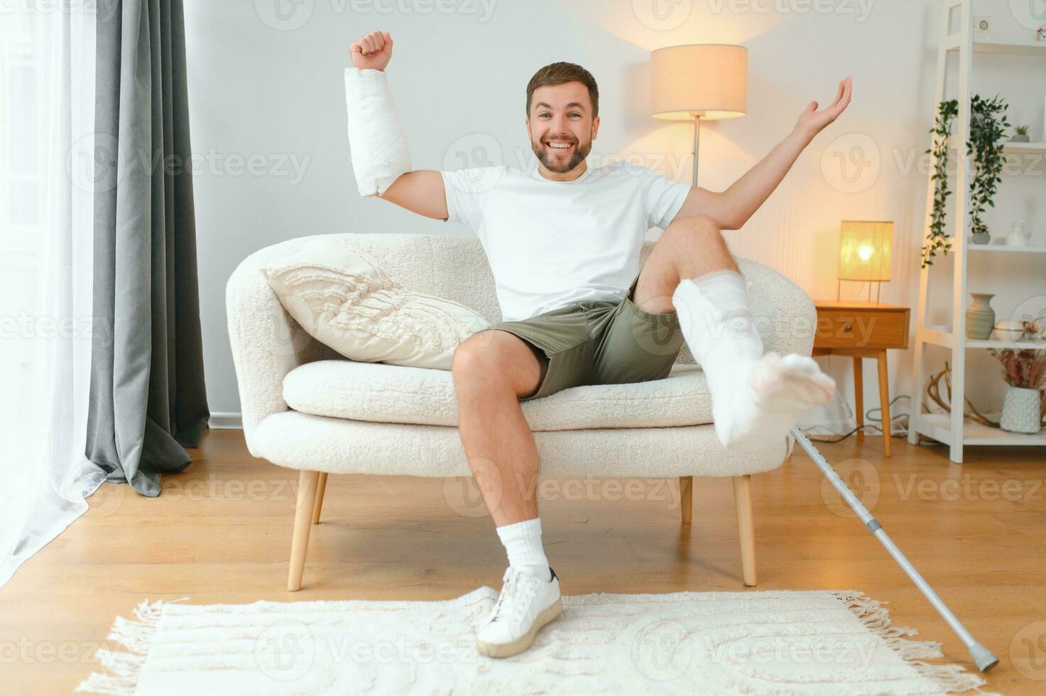 Happy man recovery from accident fracture broken bone injury with leg and arm. Social security and health insurance concept photo