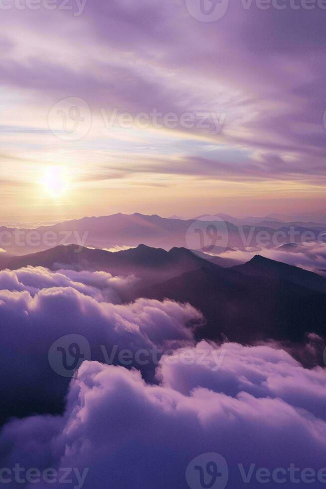 AI generated A breathtaking view of sunrise illuminating mountains amidst a sea of fluffy clouds, casting an ethereal glow. photo