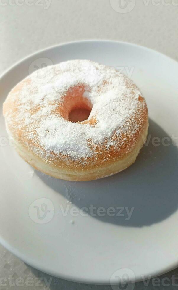 foto de blanco en polvo azúcar rosquillas en un plato Listo a comer