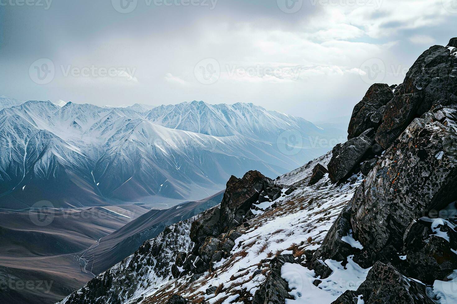 AI generated A breathtaking view of snow-capped mountains, rocky foreground under a dramatic cloudy sky, showcasing nature's grandeur. photo