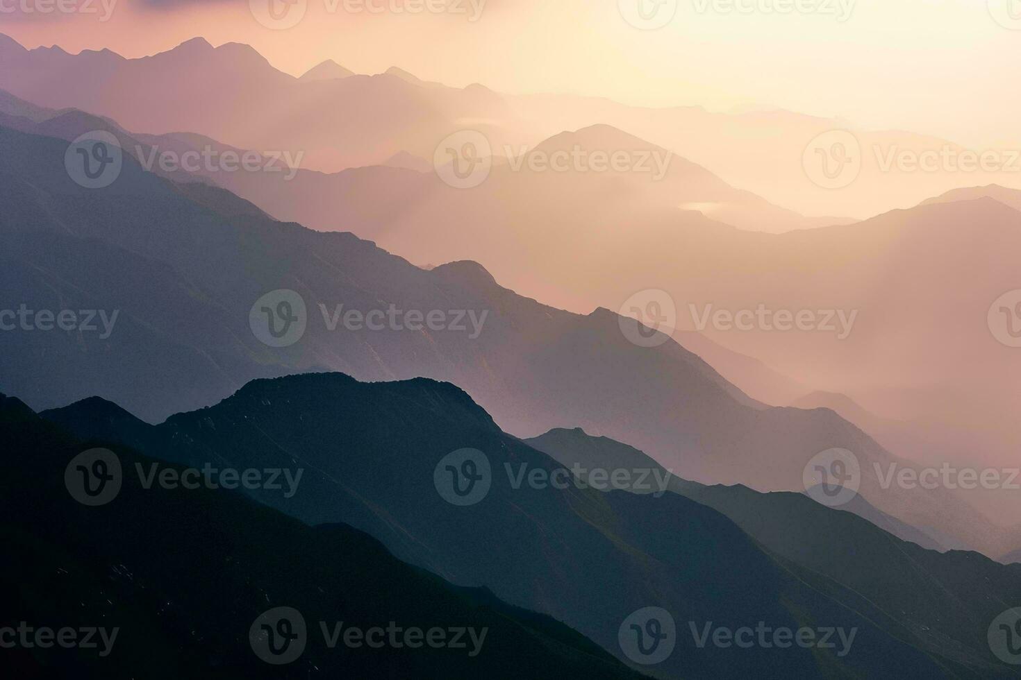 AI generated A breathtaking view of layered mountains veiled in mist, illuminated by the soft, warm hues of a setting sun. photo