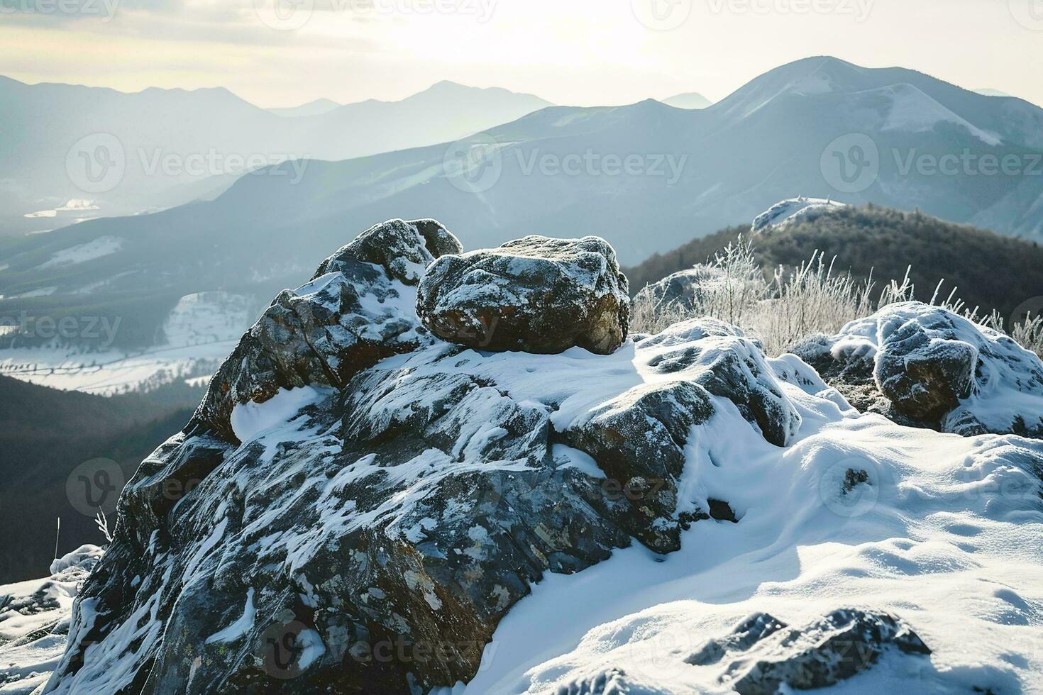 AI generated A breathtaking view of snow-covered mountains with a rocky terrain in the foreground under the soft glow of sunlight. photo