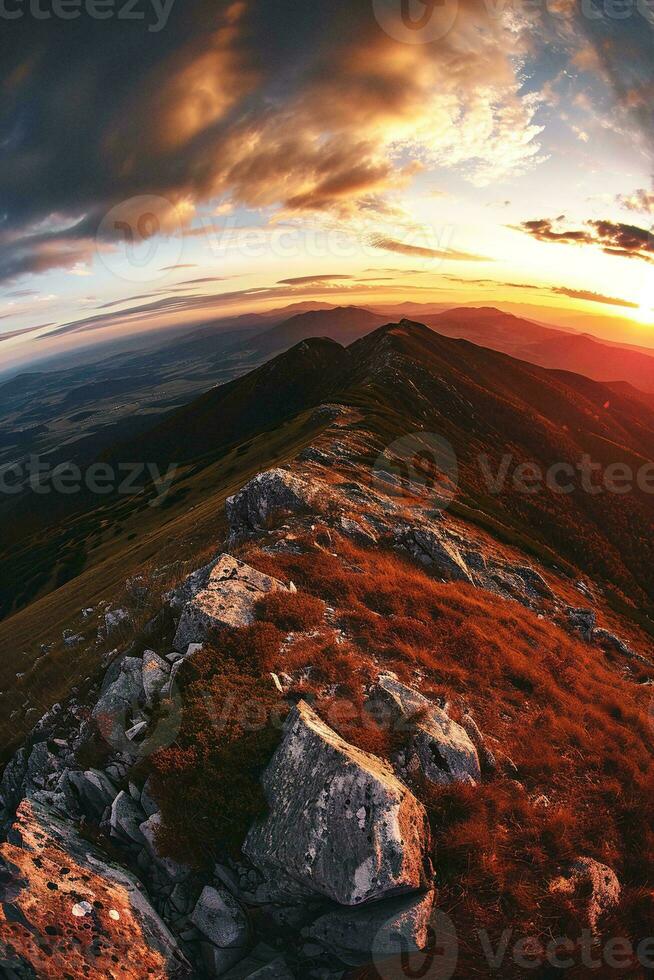 AI generated a stunning sunset amidst a mountainous landscape. The sky is painted with hues of orange, yellow, and red blending into the blue. Clouds are scattered across the sky adding photo