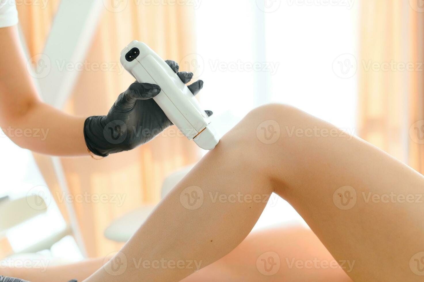 Beautician waxing female legs in spa center photo