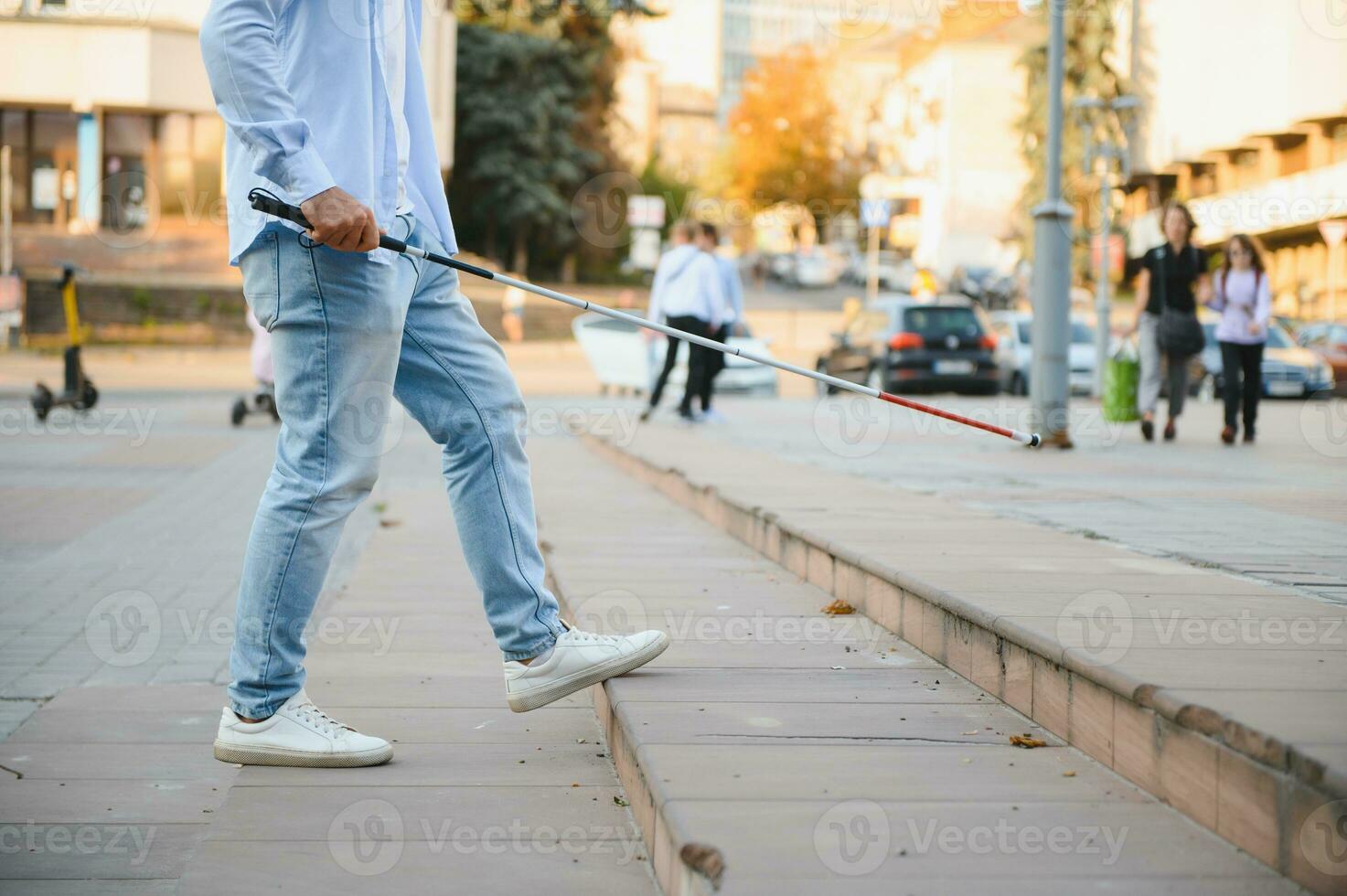 Blind man close-up with a walking stick. Walking down the street photo