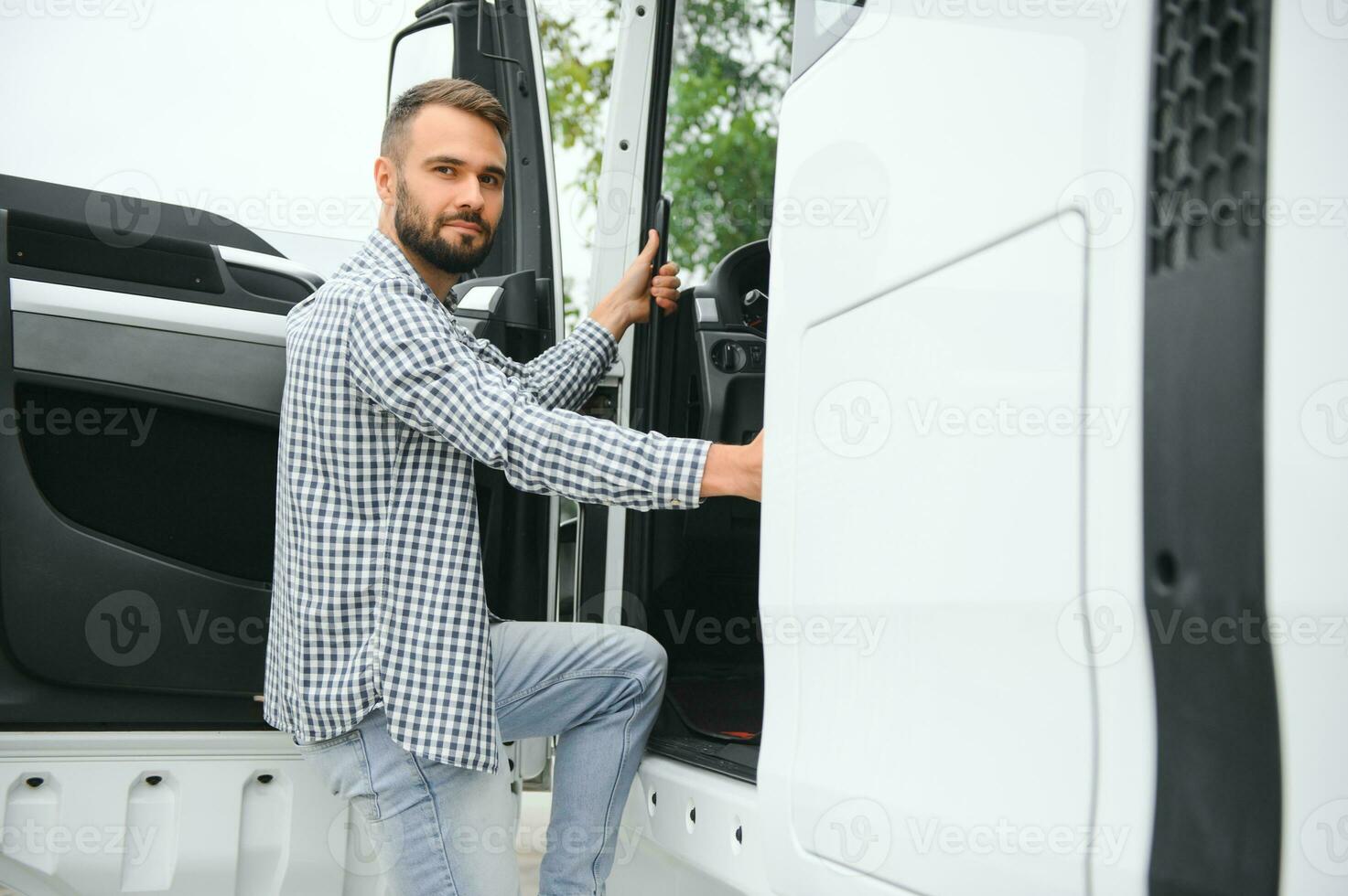 Truck driver climbing into cab of semi-truck photo