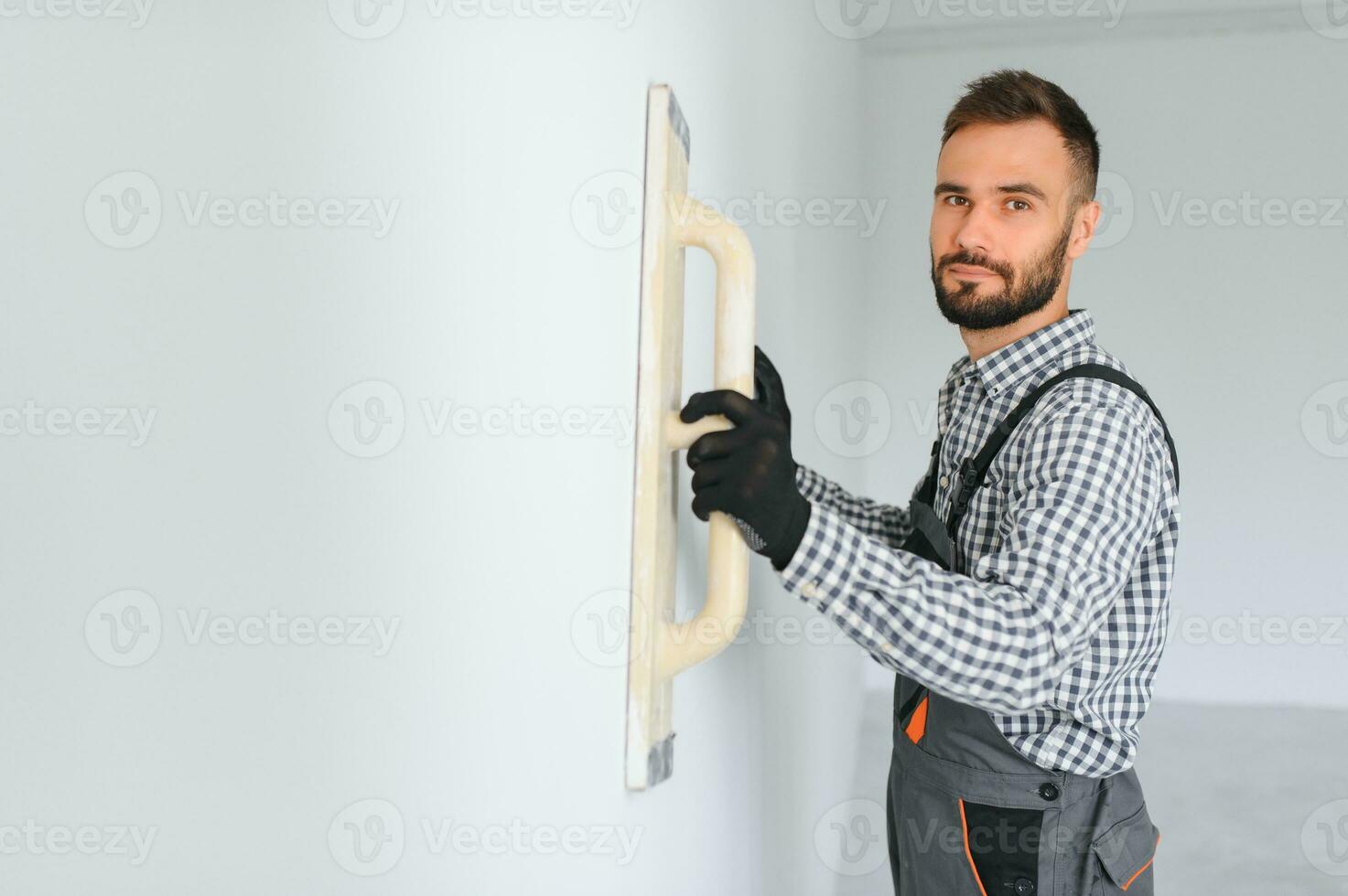 business, building, profession and people concept - builder with grinding tool indoors photo
