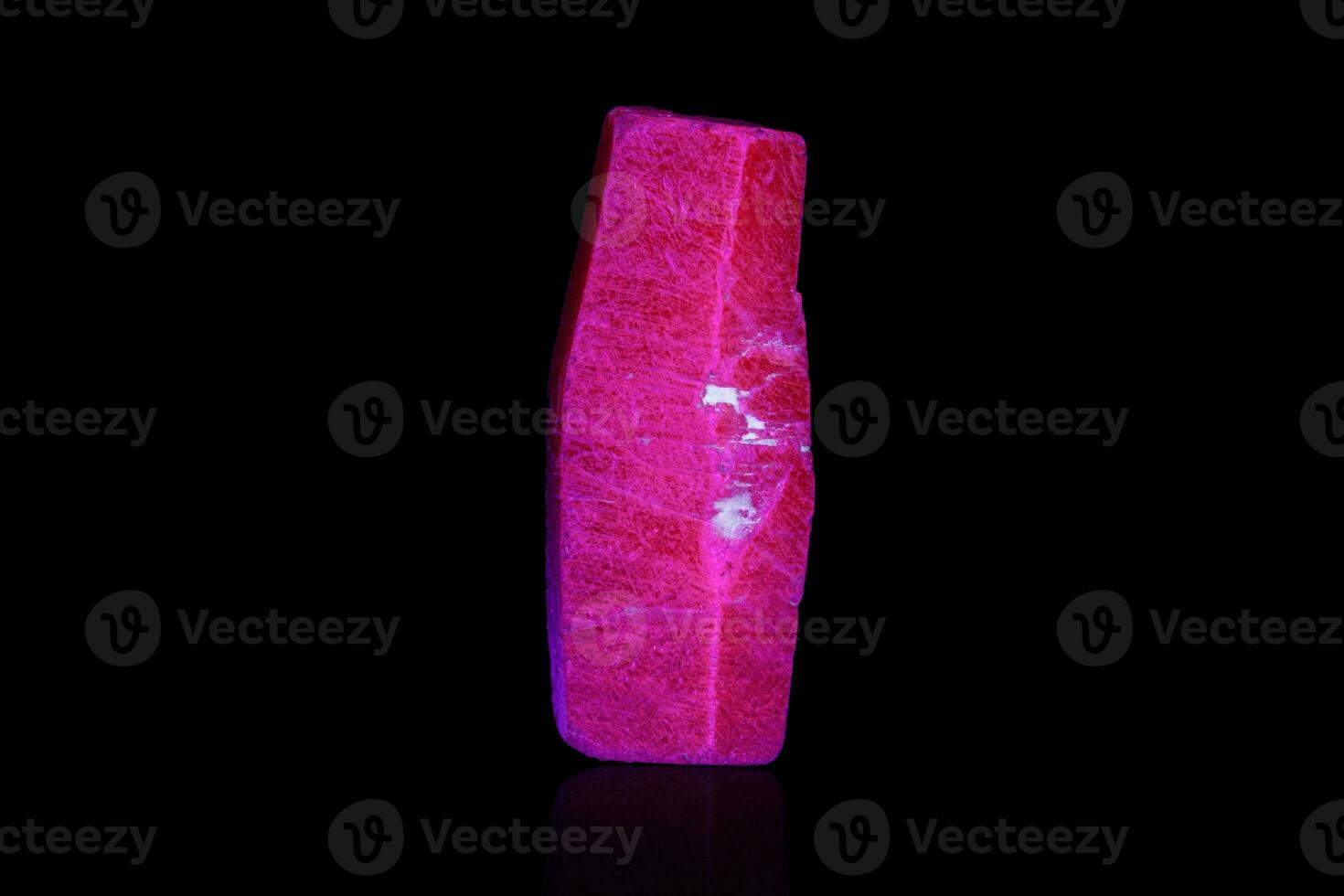 macro mineral stone ruby under ultraviolet light on a black background photo