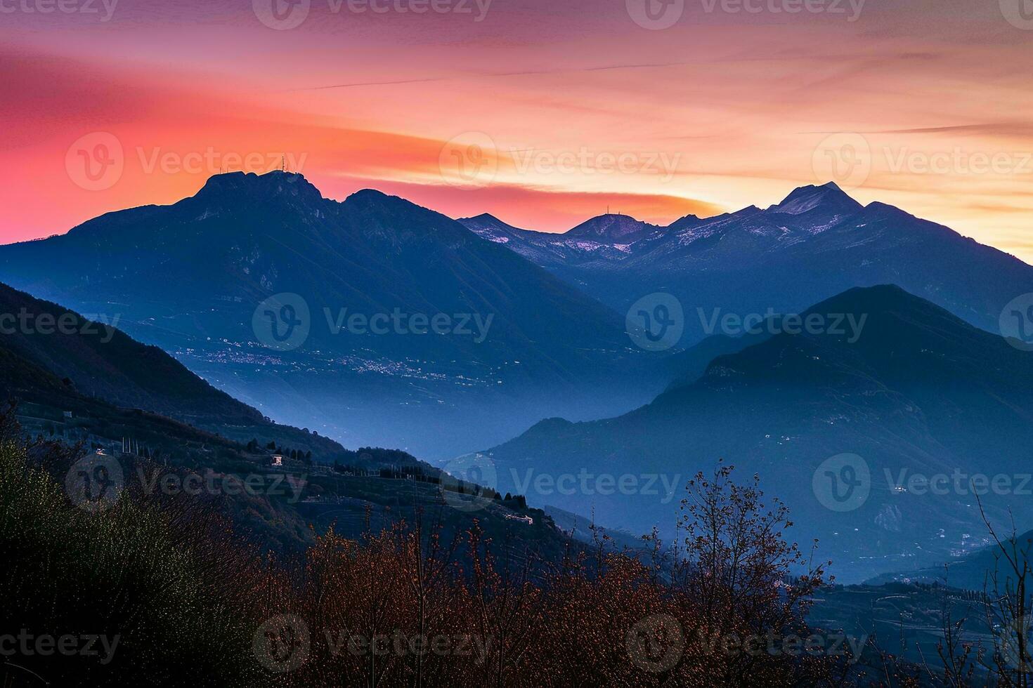 AI generated a stunning sunset over a mountain range. The sky is painted with hues of orange, red, and purple as the sun sets. photo
