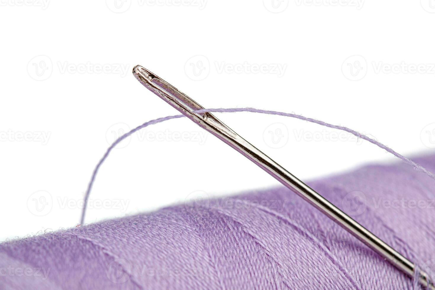 Macro skein of thread purple colors with a needle on a white background photo