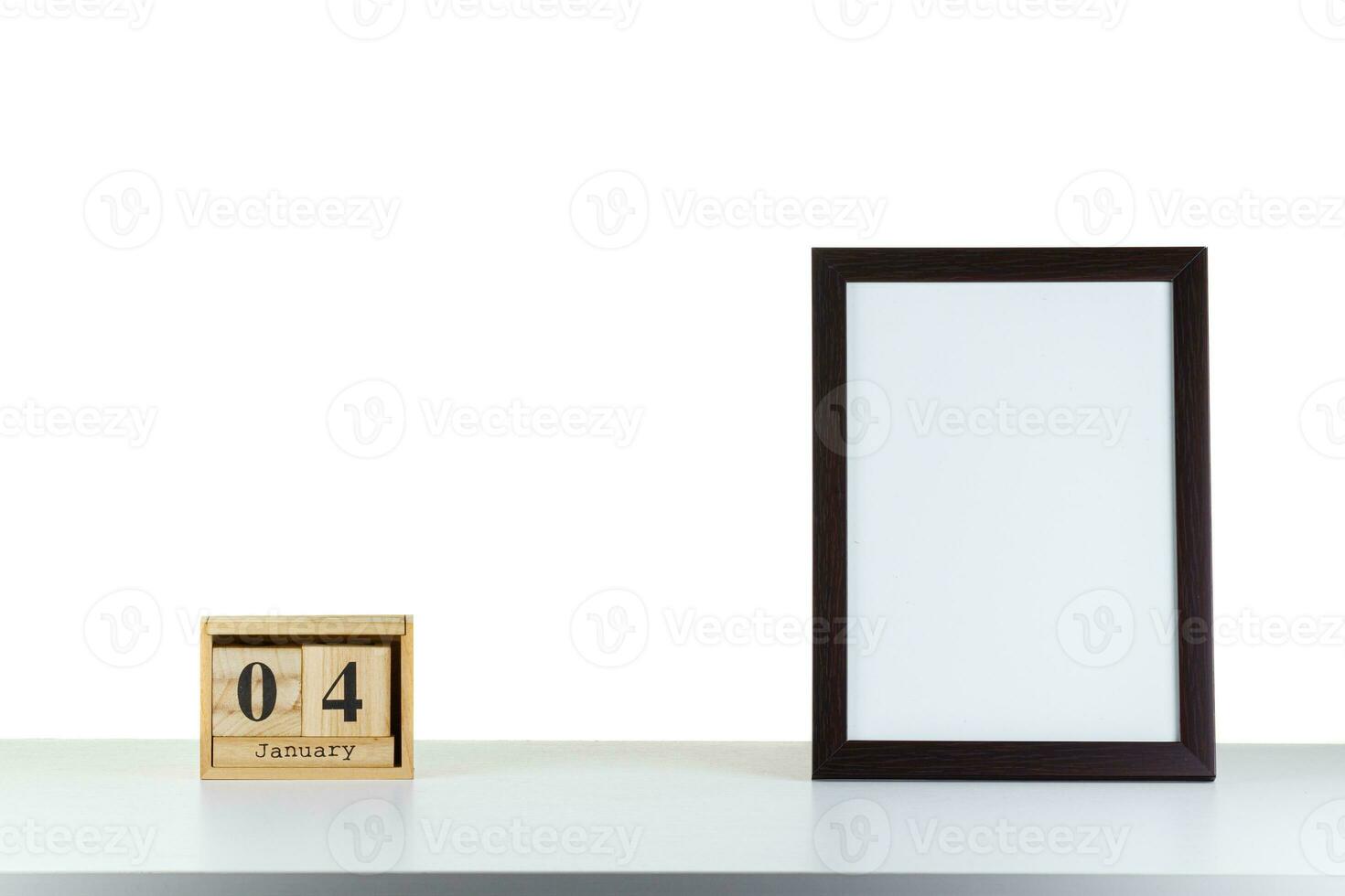 Wooden calendar 04 January with frame for photo on white table and background