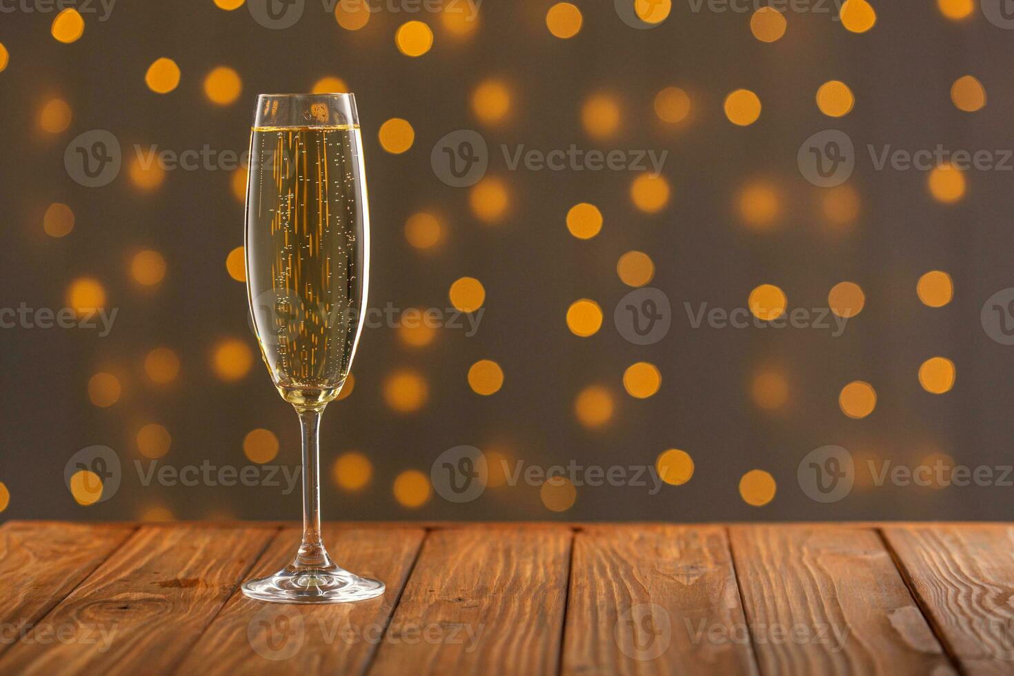 Glasses with champagne on a wooden background against a bokeh background of lights photo