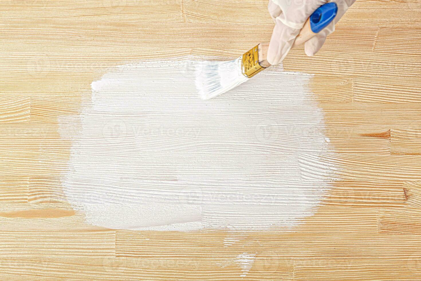 white paint with a brush painting a wooden background with texture photo