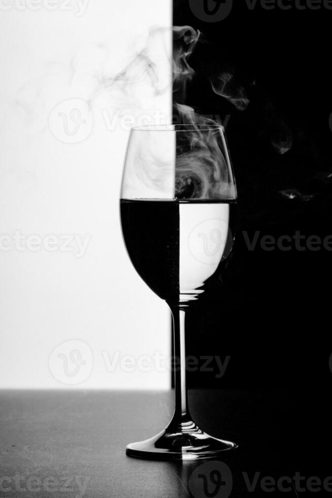 a glass of water and smoke on a black and white background photo