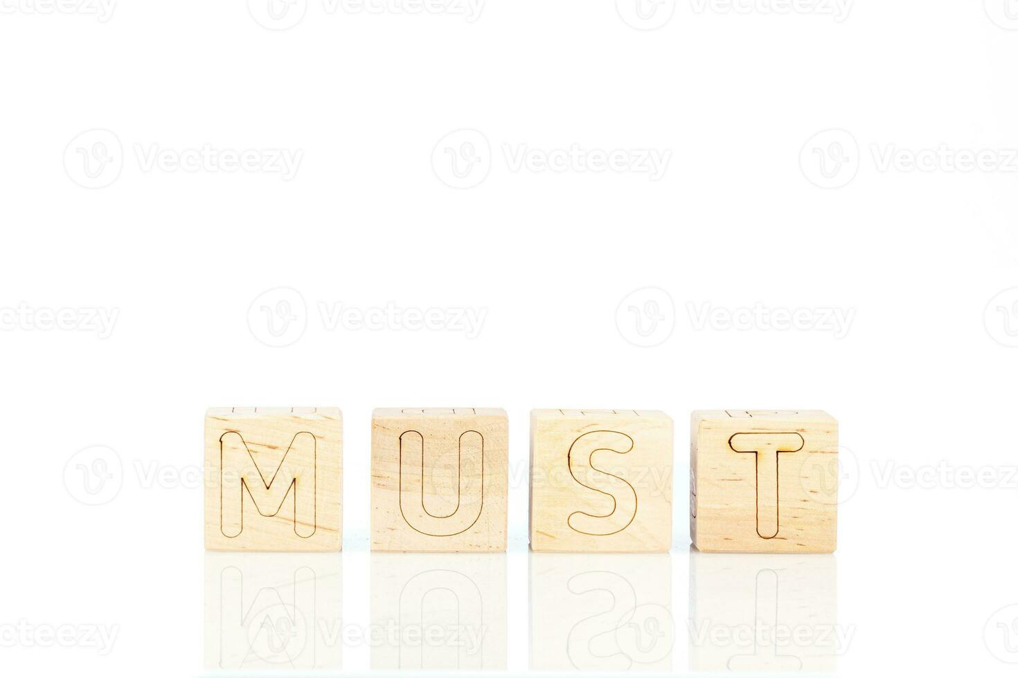 Wooden cubes with letters Must on a white background photo