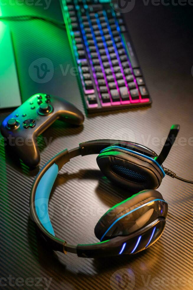 Top view of gamer workspace and gear headset, mouse, keyboard, joystick, VR on black table photo