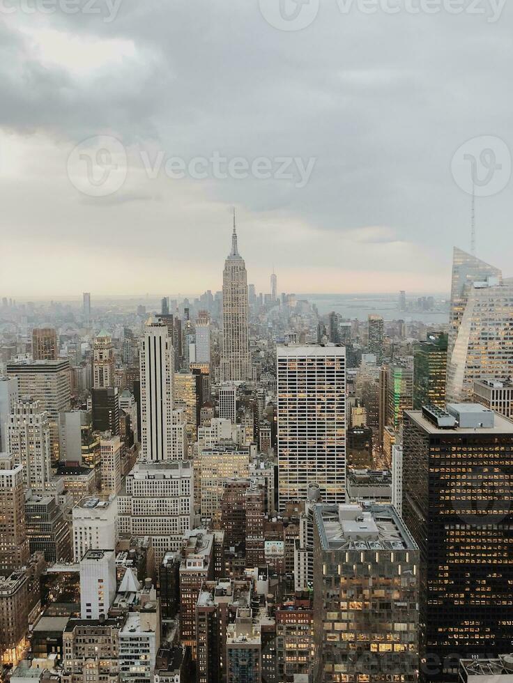 Aerial view of a city skyline with iconic skyscrapers under a cloudy sky, showcasing urban architecture. photo