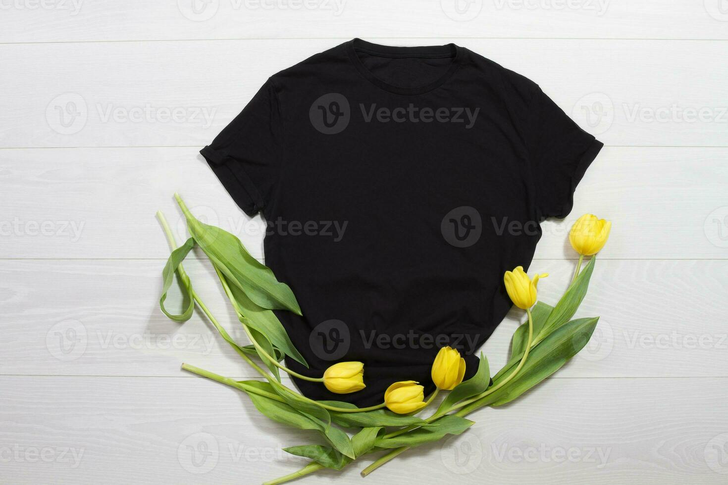 Black t-shirt mockup. Template blank shirt top view. White wooden background. Mother women day holiday. Yellow tulips. Woman tshirt with birthday bouquet flowers. Spring look. Female accessories photo