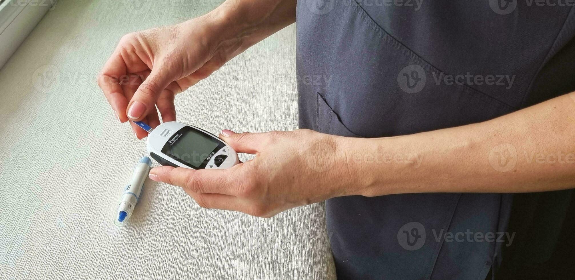 cerca arriba Disparo de el glucómetro instrumento en el blanco superficie. cuidado de la salud foto