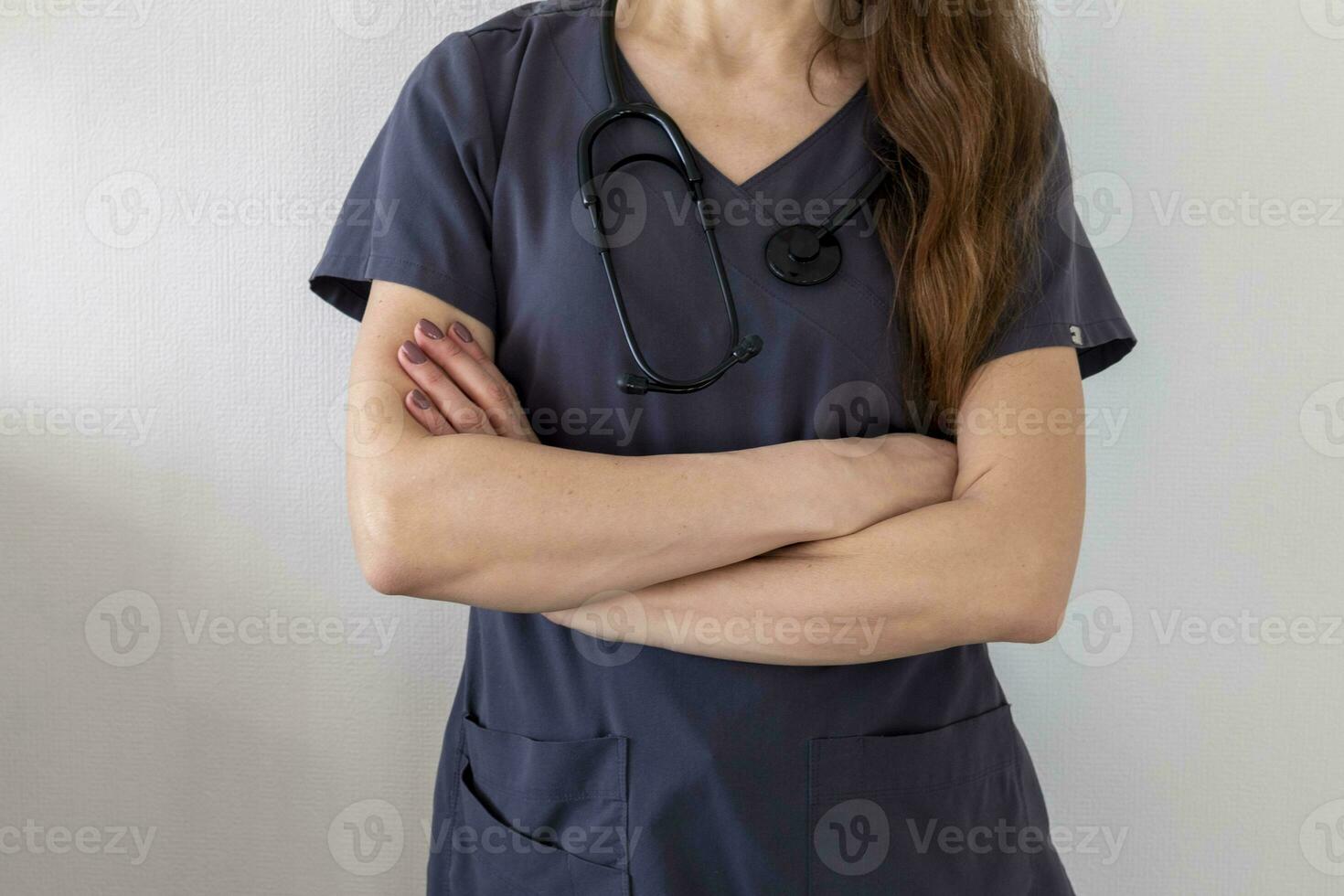 Shot of the female doctor in uniform against the white wall. Healthcare photo