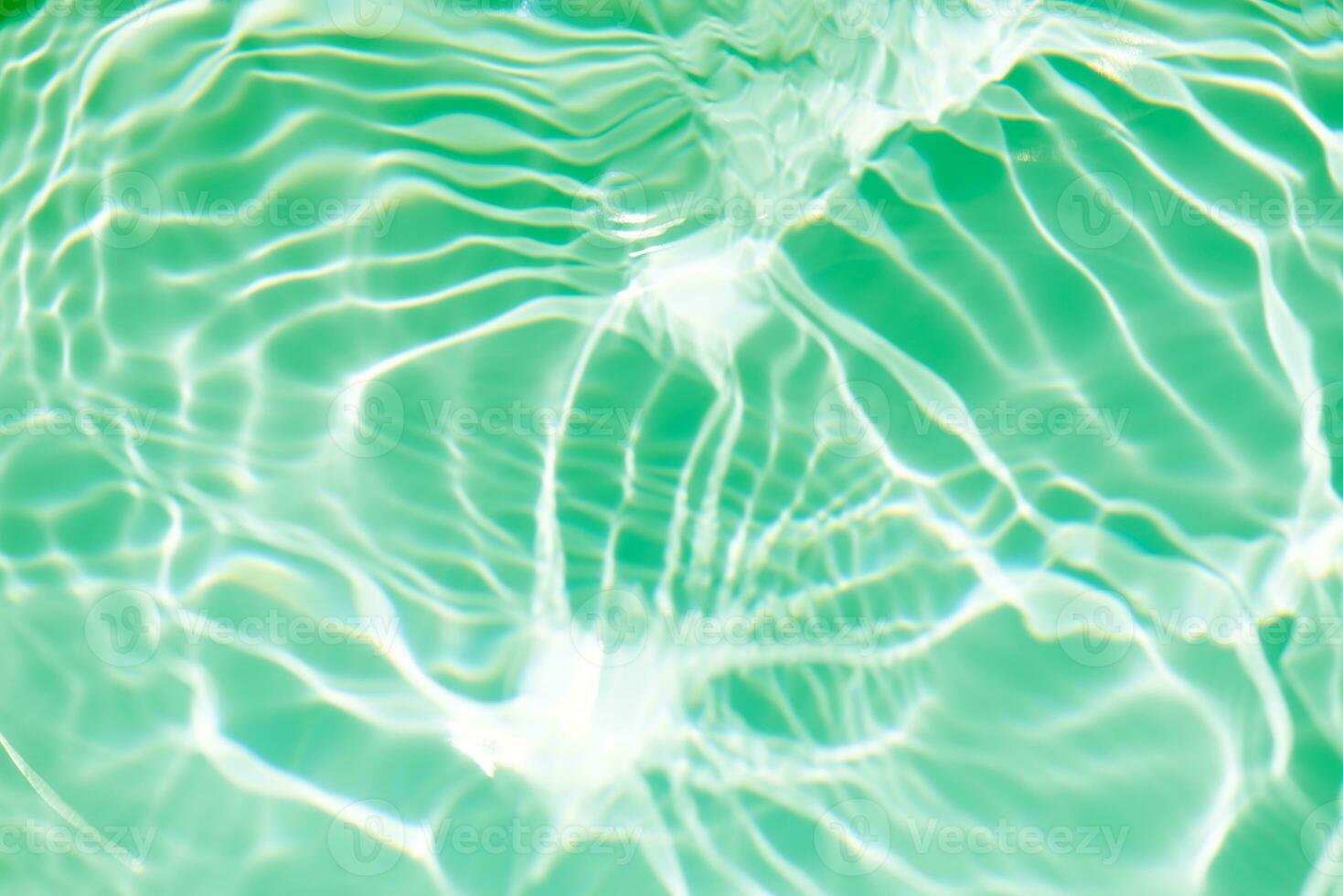 Bluewater waves on the surface ripples blurred. Defocus blurred transparent blue colored clear calm water surface texture with splash and bubbles. Water waves with shining pattern texture background. photo