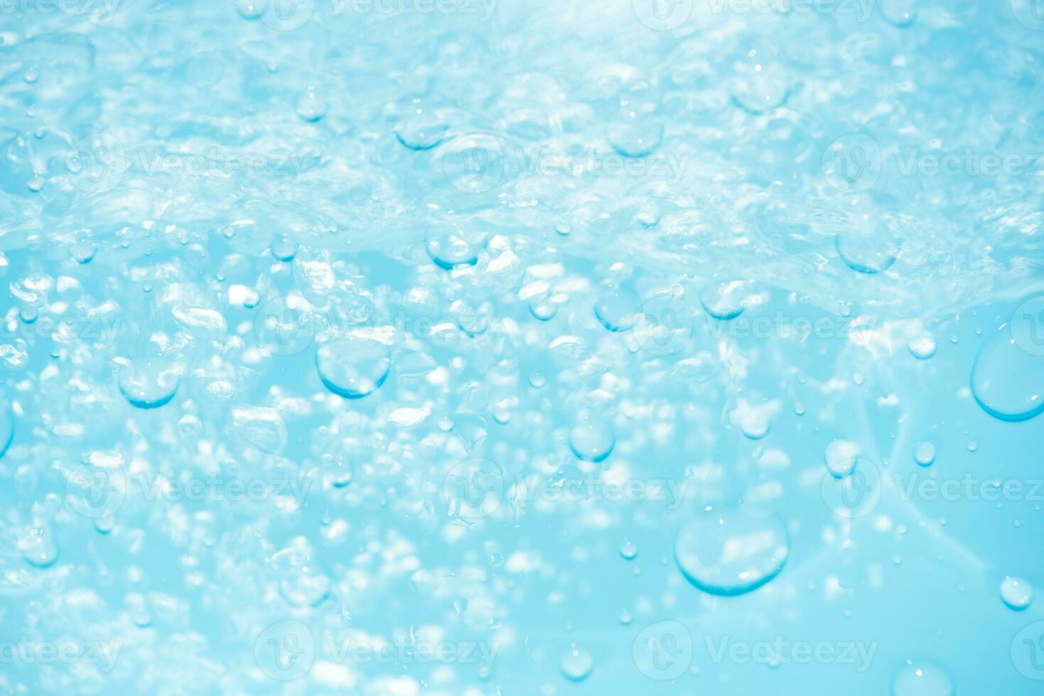 Bluewater waves on the surface ripples blurred. Defocus blurred transparent blue colored clear calm water surface texture with splash and bubbles. Water waves with shining pattern texture background. photo