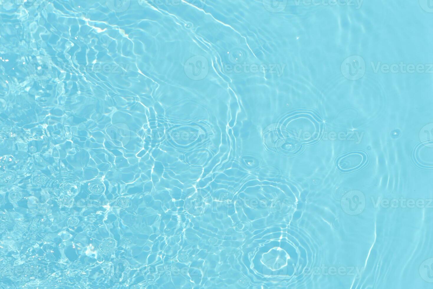 Defocus blurred transparent blue colored clear calm water surface texture with splashes and bubbles. Trendy abstract nature background. Water waves in sunlight with copy space. Blue watercolor shining photo