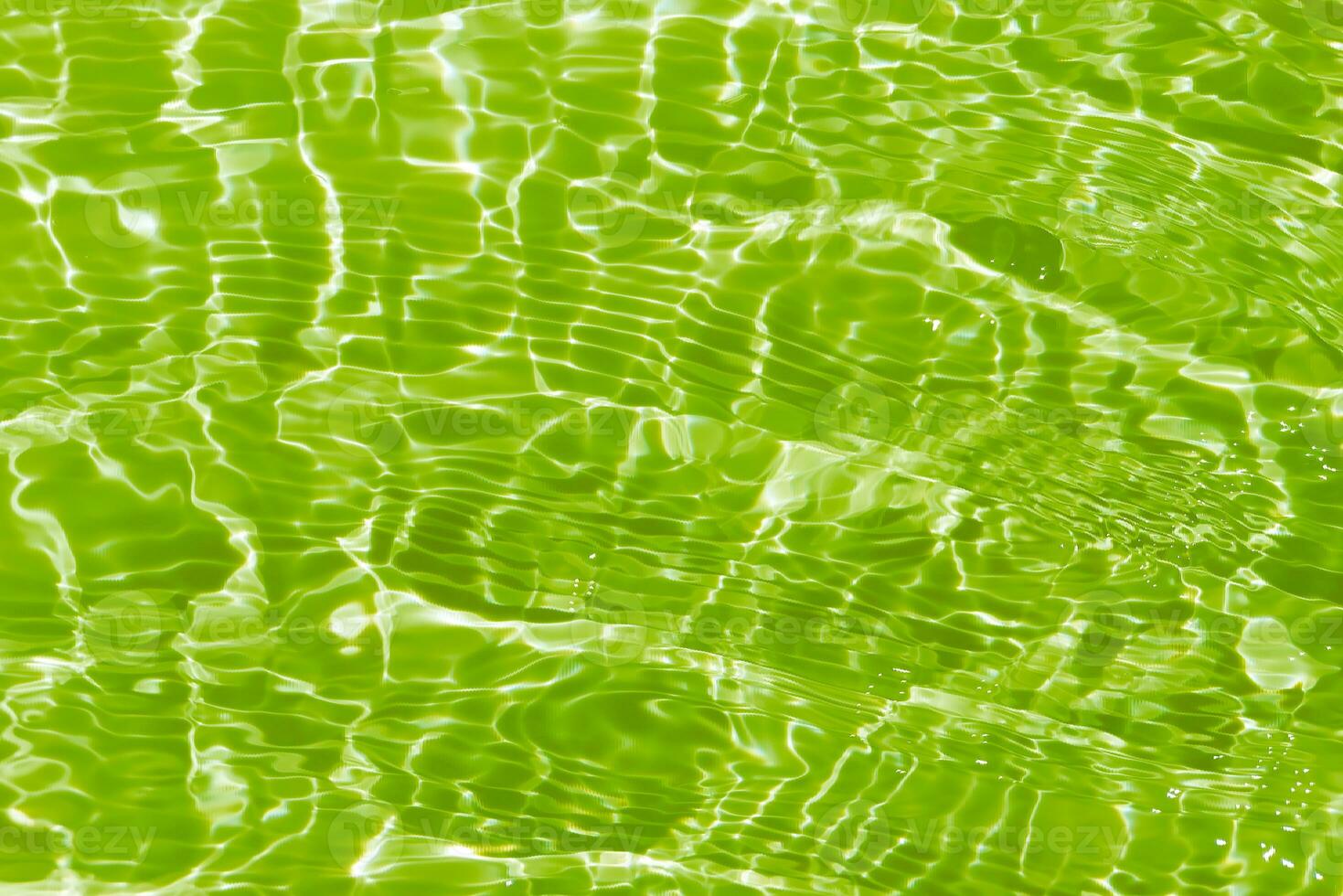 Green water waves on the surface ripple blurred. Defocus blurred transparent blue colored clear calm water surface texture with splash and bubbles. Water waves with shining pattern texture background. photo