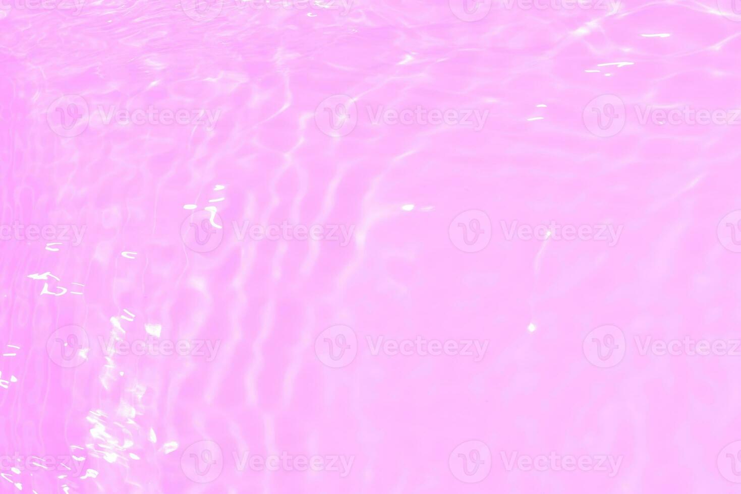 Purple water splashes on the surface ripple blur. Defocus blurred transparent pink colored clear calm water surface texture with splash and bubble. Water waves with shining pattern texture background. photo