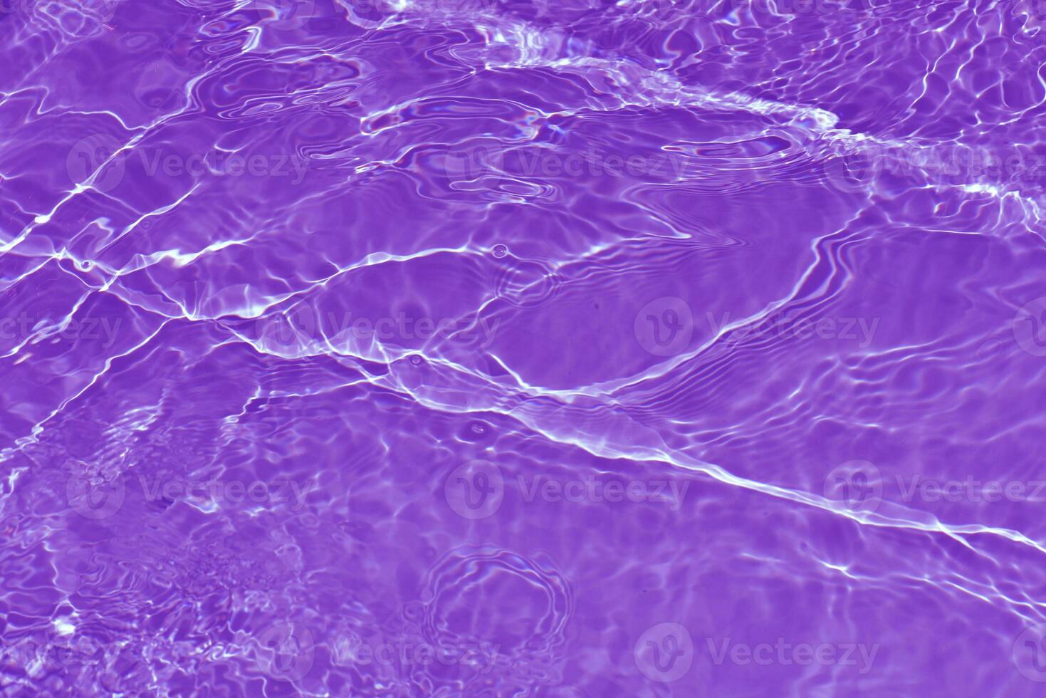 Purple water waves on the surface ripples blur. Defocus blurred transparent pink colored clear calm water surface texture with splash and bubbles. Water waves with shining pattern texture background. photo