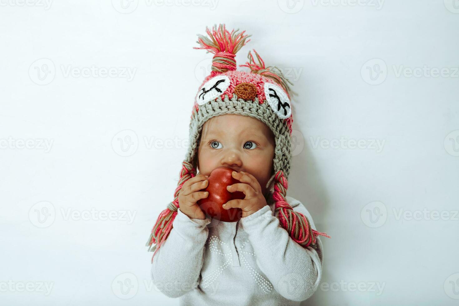Little girl biting a red apple photo