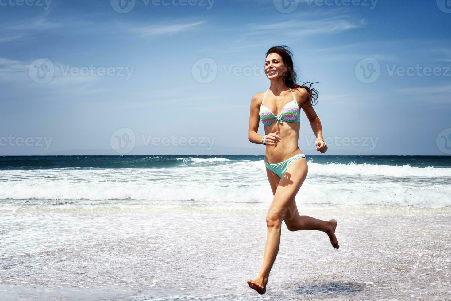 Woman running on a beach photo