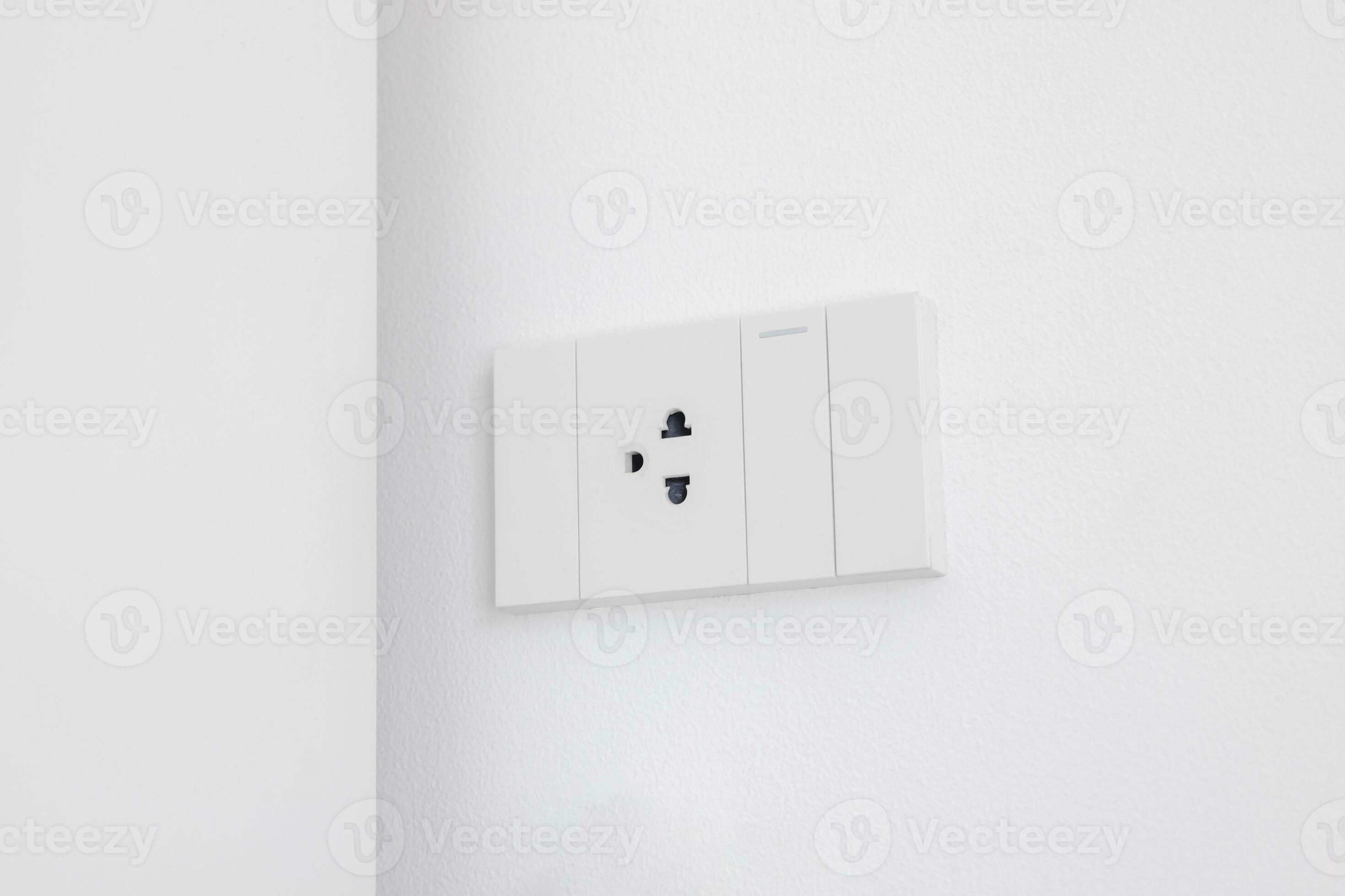 Modern white electrical sockets and light switches on white wall. Plug