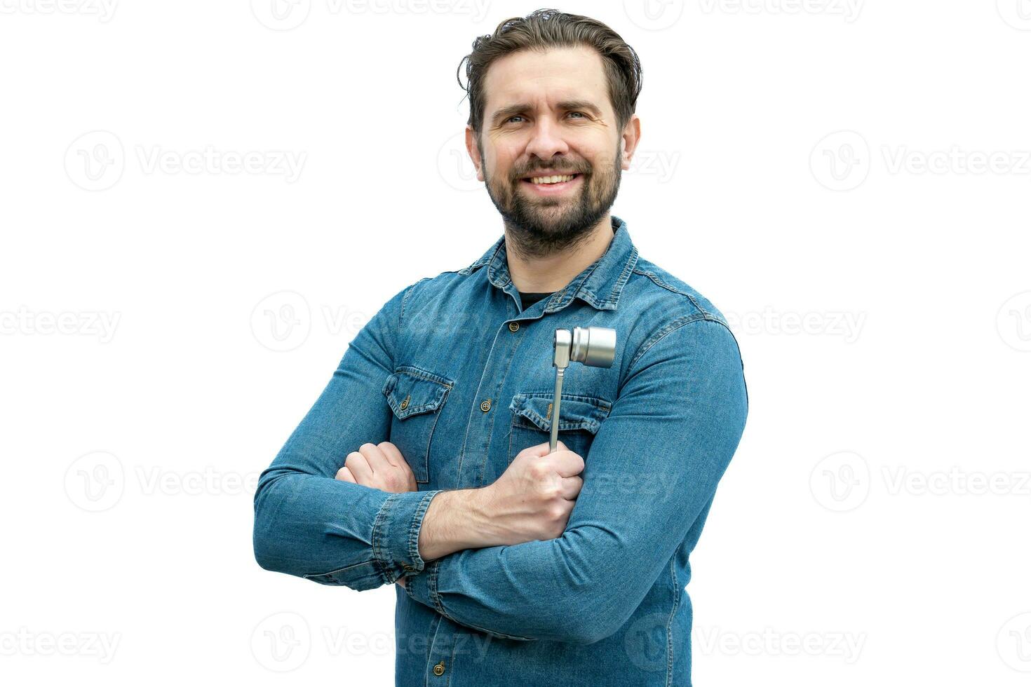 joven sonriente mecánico participación un trinquete llave inglesa en su manos. foto