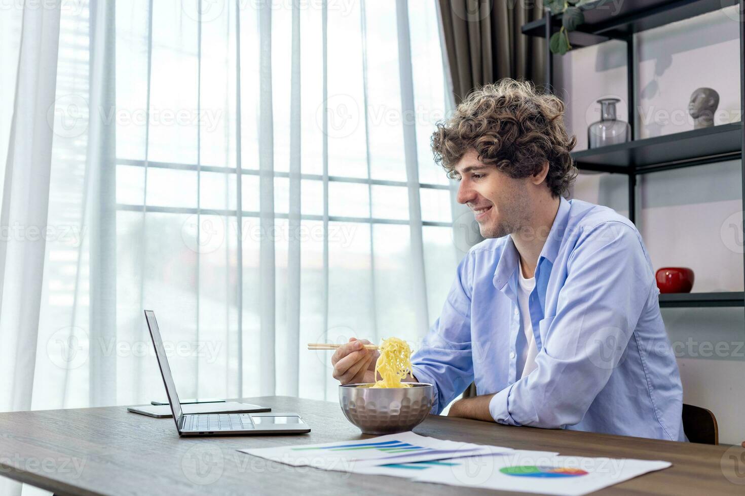 Caucasian man is working at his home office while eating instant noodle and analyzing the statistic chart for freelance and entrepreneur business concept photo
