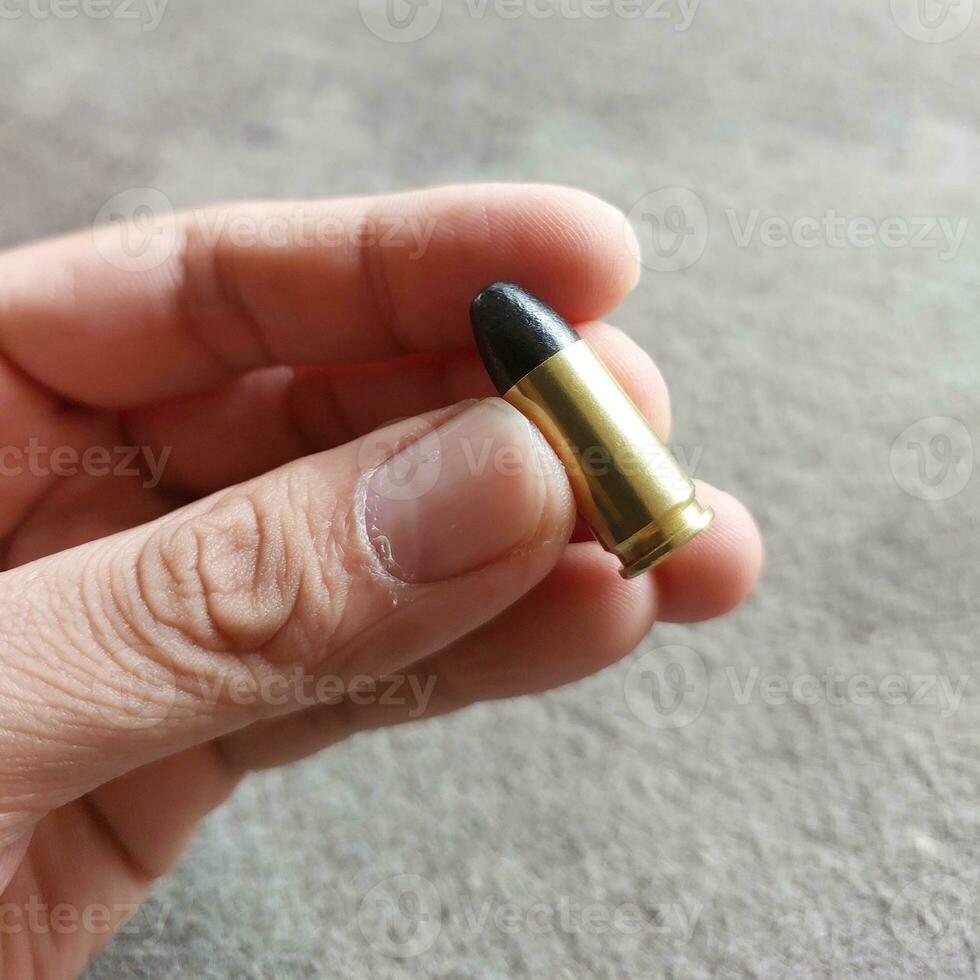 Close up of 9mm bullet in hand, sport shooting range. Small bullet in a hand. photo