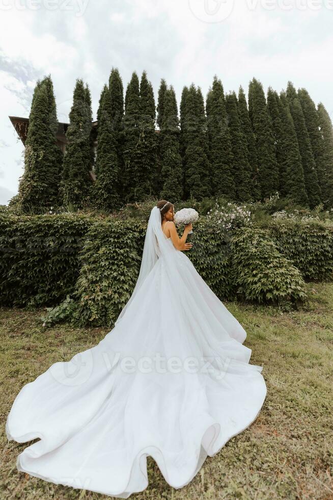 Beautiful bride with wedding flowers bouquet, attractive woman in wedding dress. Happy newlywed woman. Bride with wedding makeup and hairstyle. Smiling bride. Wedding day. Gorgeous bride. Marriage. photo