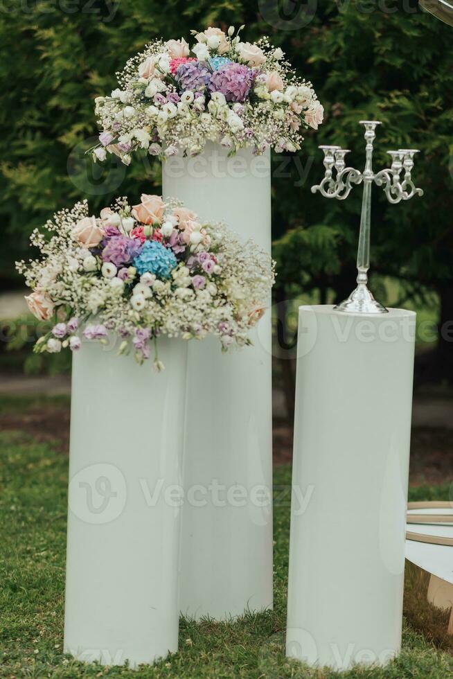 wedding ceremony in the garden. A luxurious wedding ceremony. Romantic wedding ceremony. The stands are decorated with colorful flowers. photo