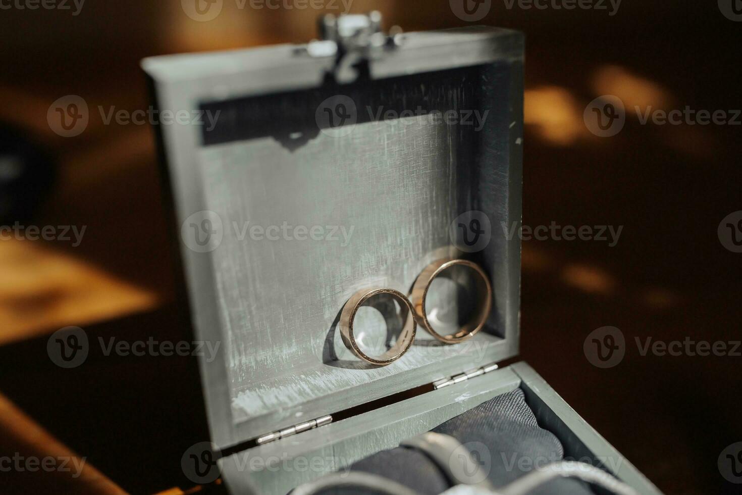 Photo of wedding accessories. Gold rings in an elegant gray box. Style and fashion