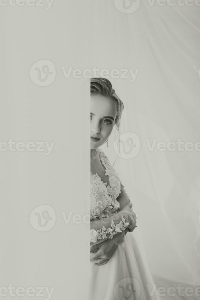 Beautiful bride. Wedding hairstyle - on a white background. Close-up portrait of a young gorgeous bride. Wedding. Portrait of a beautiful bride wrapped in a veil photo