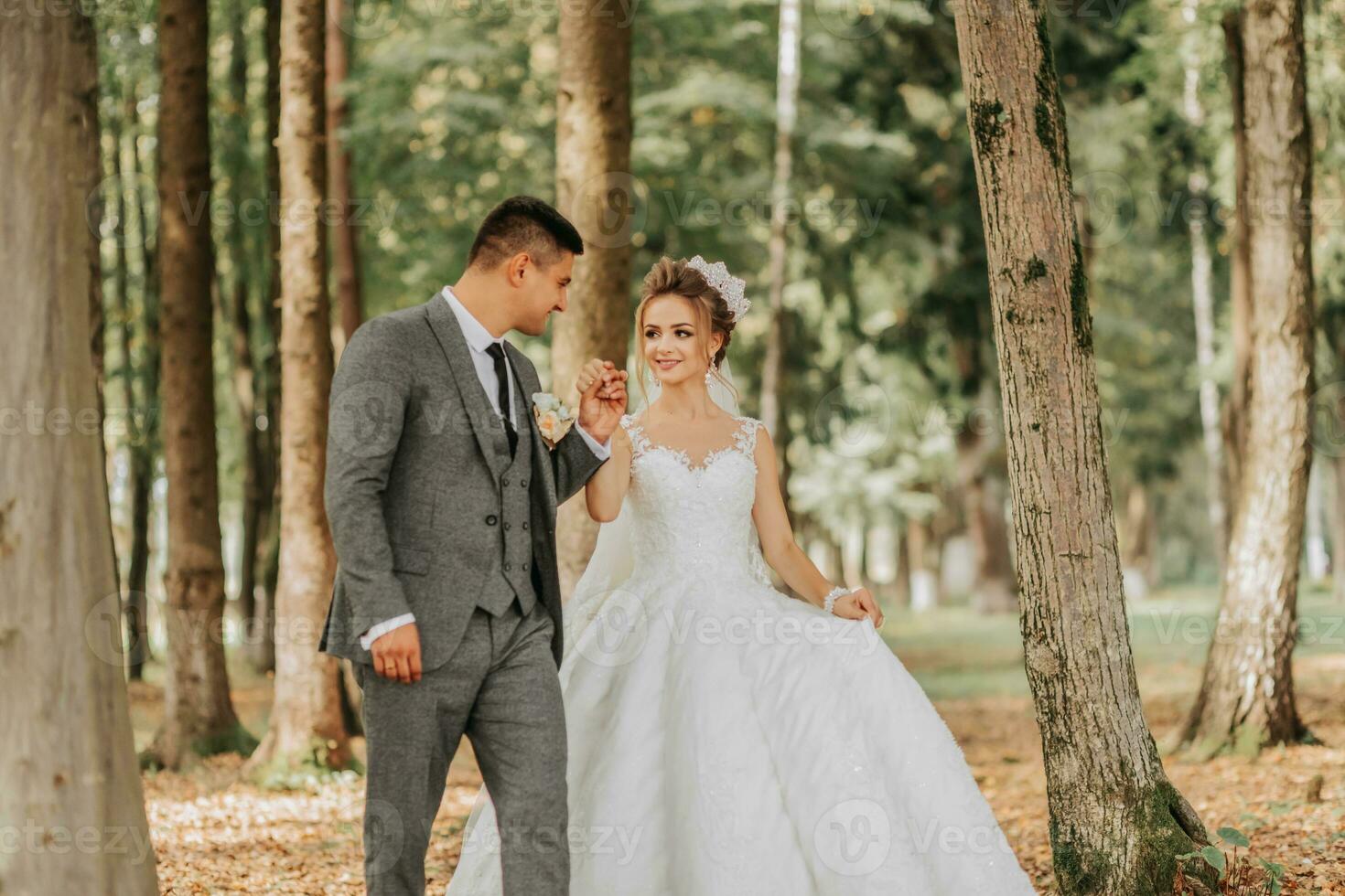 el novia y novio caminar mano en mano mediante el bosque. contento Pareja. Boda foto. Pareja en amor. alto árboles, gran angular foto. Perfecto ligero foto