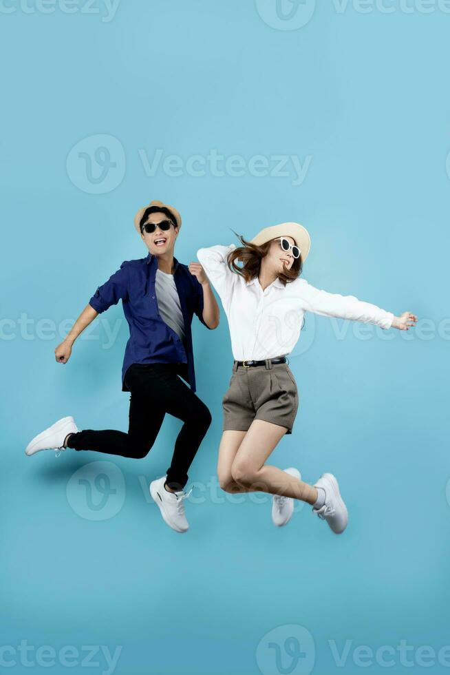 Asian couple jumping for joy isolated on blue background. photo