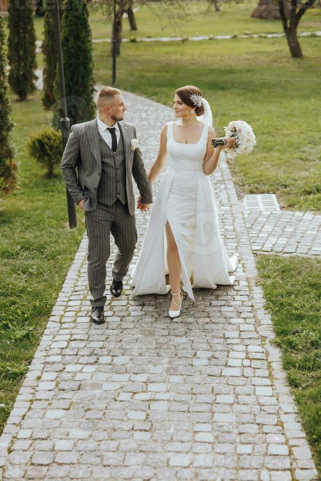 Stylish young brides, happy on their day, enjoy each other. They are walking in the spring park. Spring wedding. Natural makeup photo