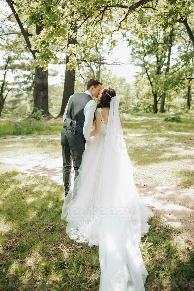 Stylish young brides, happy on their day, enjoy each other. They are walking in the spring park. Photo from the back. Spring wedding. Natural makeup