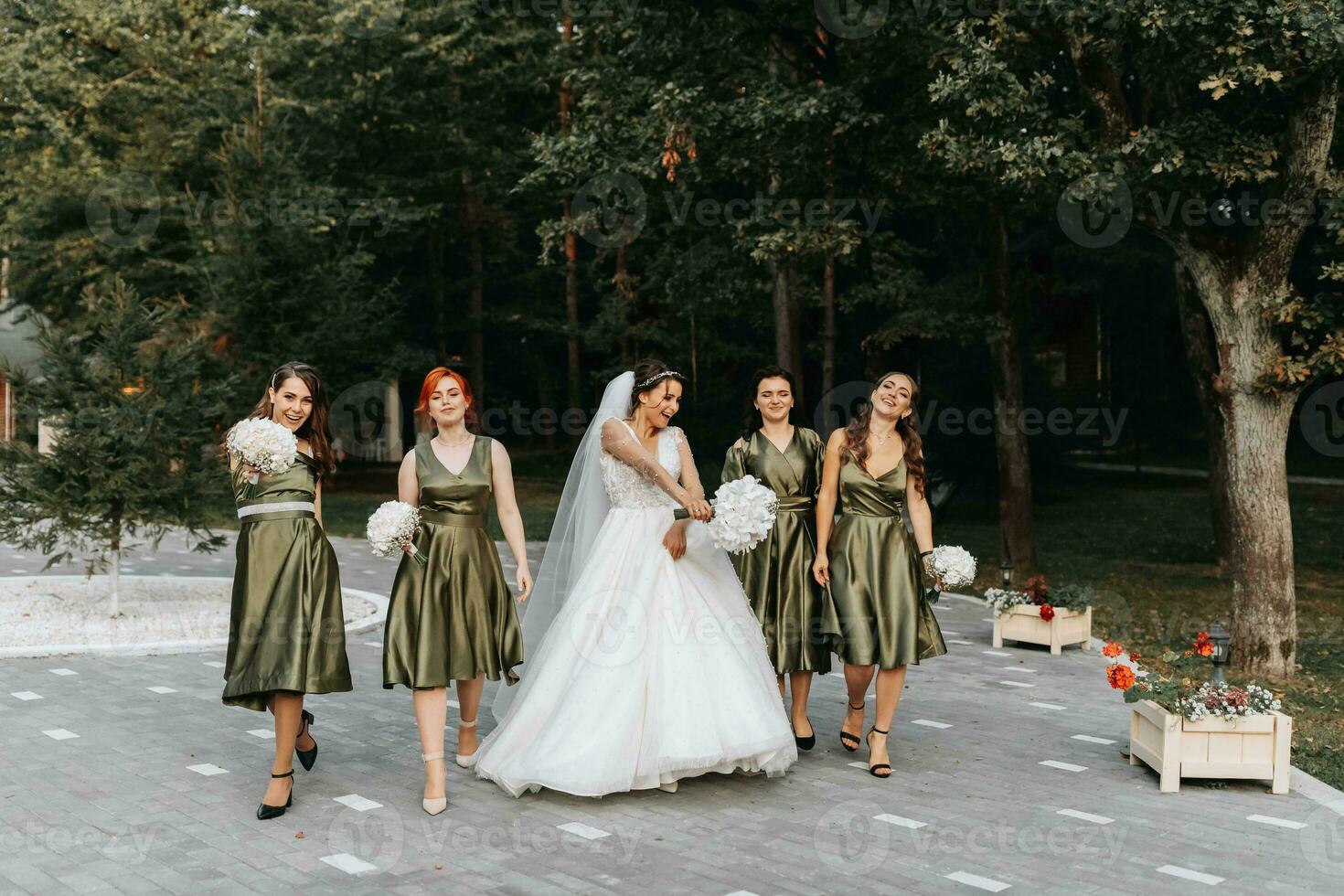 Beautiful bride and her friends- bridesmaids having fun after wedding ceremony. Happy girls at their best friend's wedding. Beautiful and elegant bride with bridesmaids walking on the stairs photo