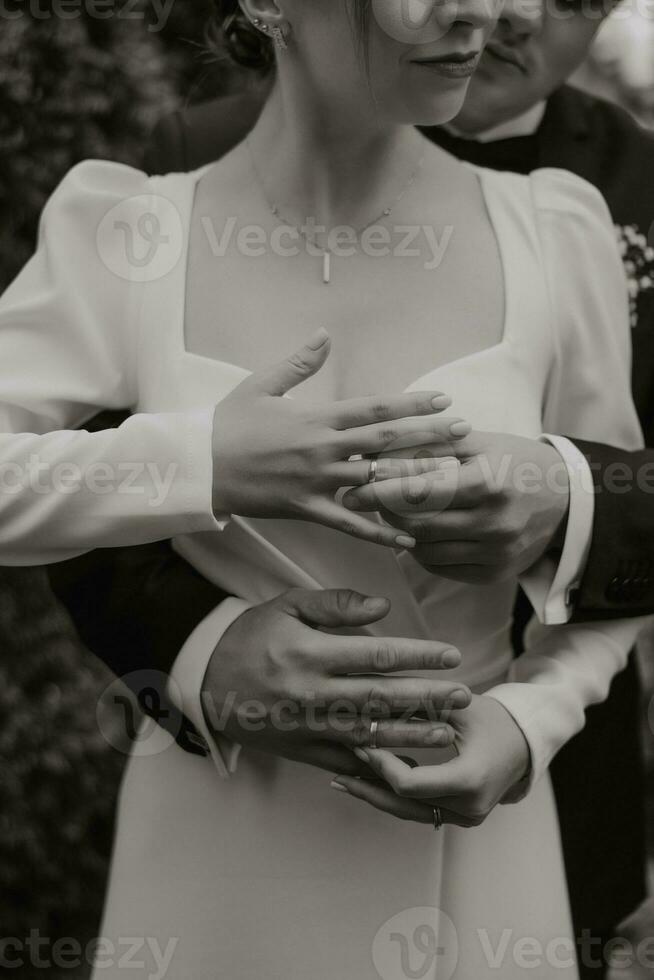 newlyweds with rings on fingers. Wedding ceremony outdoor. The couple exchanges the wedding rings. Just married. the bride and groom embrace and put on wedding rings photo