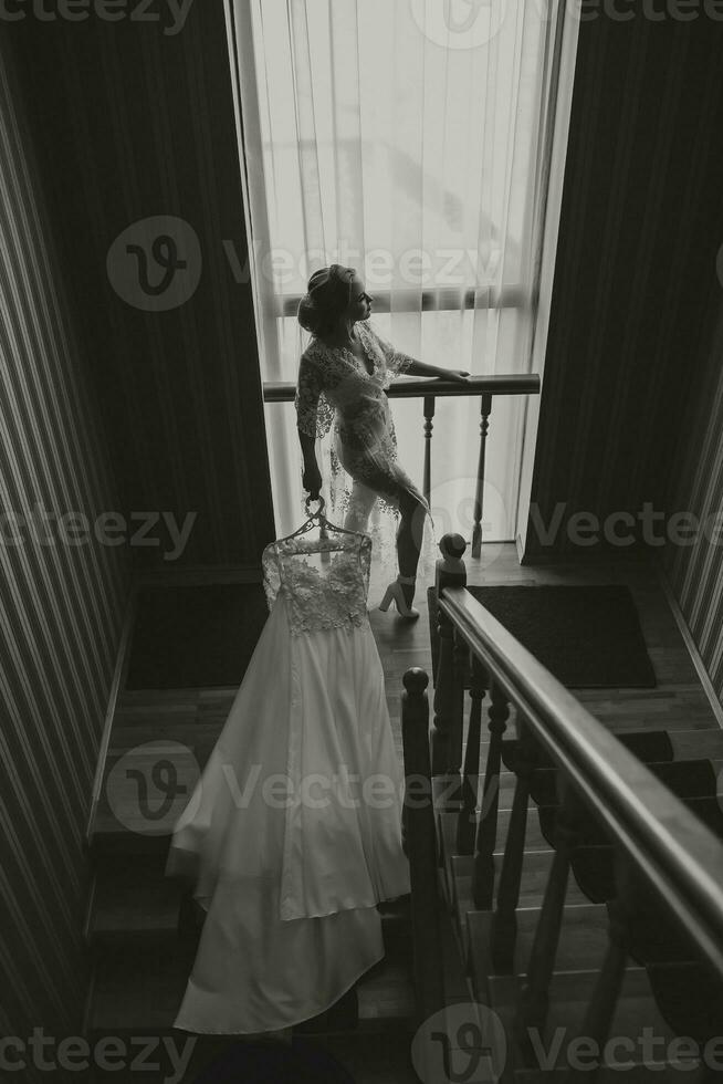 Fashion photo, a beautiful girl in a transparent robe. Fashion, glamor concept. The morning of the bride, the bride in a robe, photo from the front. Black and white photo