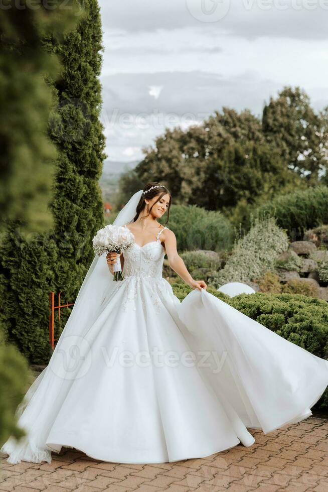 Beautiful bride with wedding flowers bouquet, attractive woman in wedding dress. Happy newlywed woman. Bride with wedding makeup and hairstyle. Smiling bride. Wedding day. Gorgeous bride. Marriage. photo