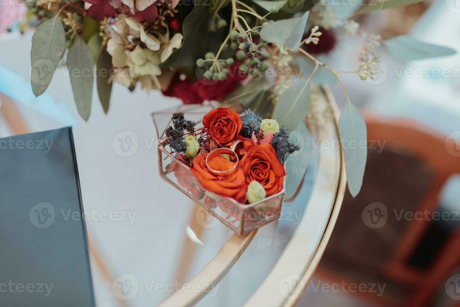 Gold wedding rings stand in vivid different colors, a decorated glass box. Wedding accessories. Preparation for wedding ceremonies photo