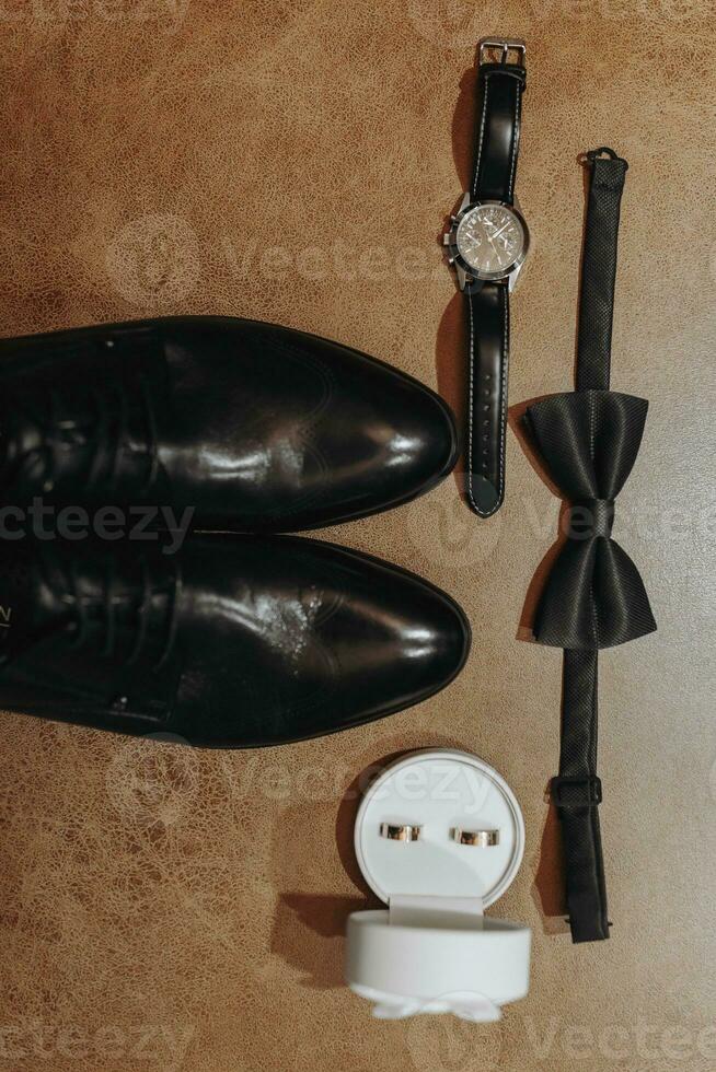 The morning of the groom and details, the details of the groom are dark. men's watch, wedding rings, men's bow tie photo